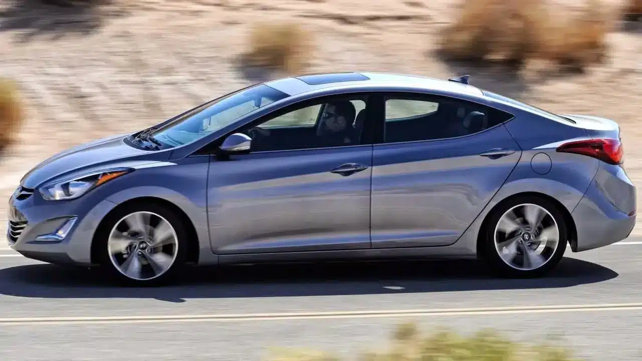 A silver Hyundai Elantra driving through a desert landscape, known for its affordability and fuel efficiency.