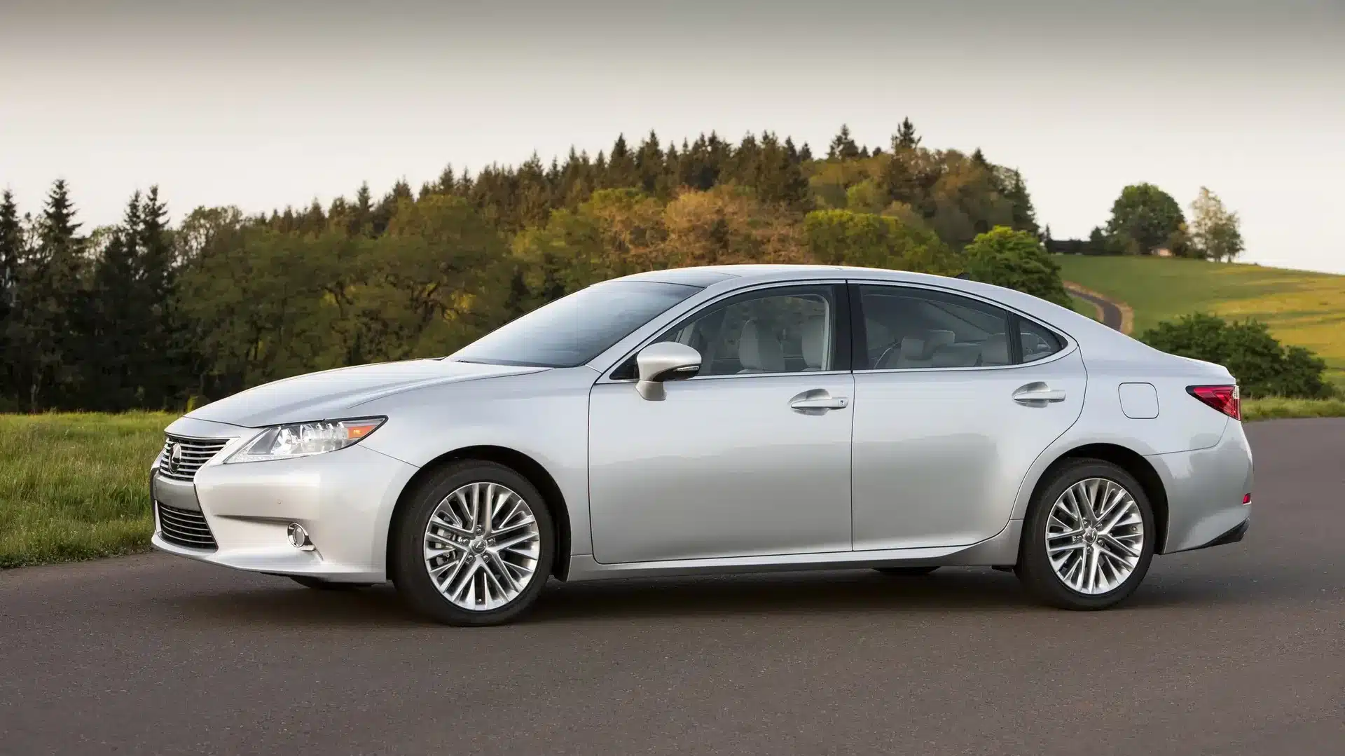 Silver Lexus ES 350 parked in a countryside setting, known for its luxury and reliability as a top used car.