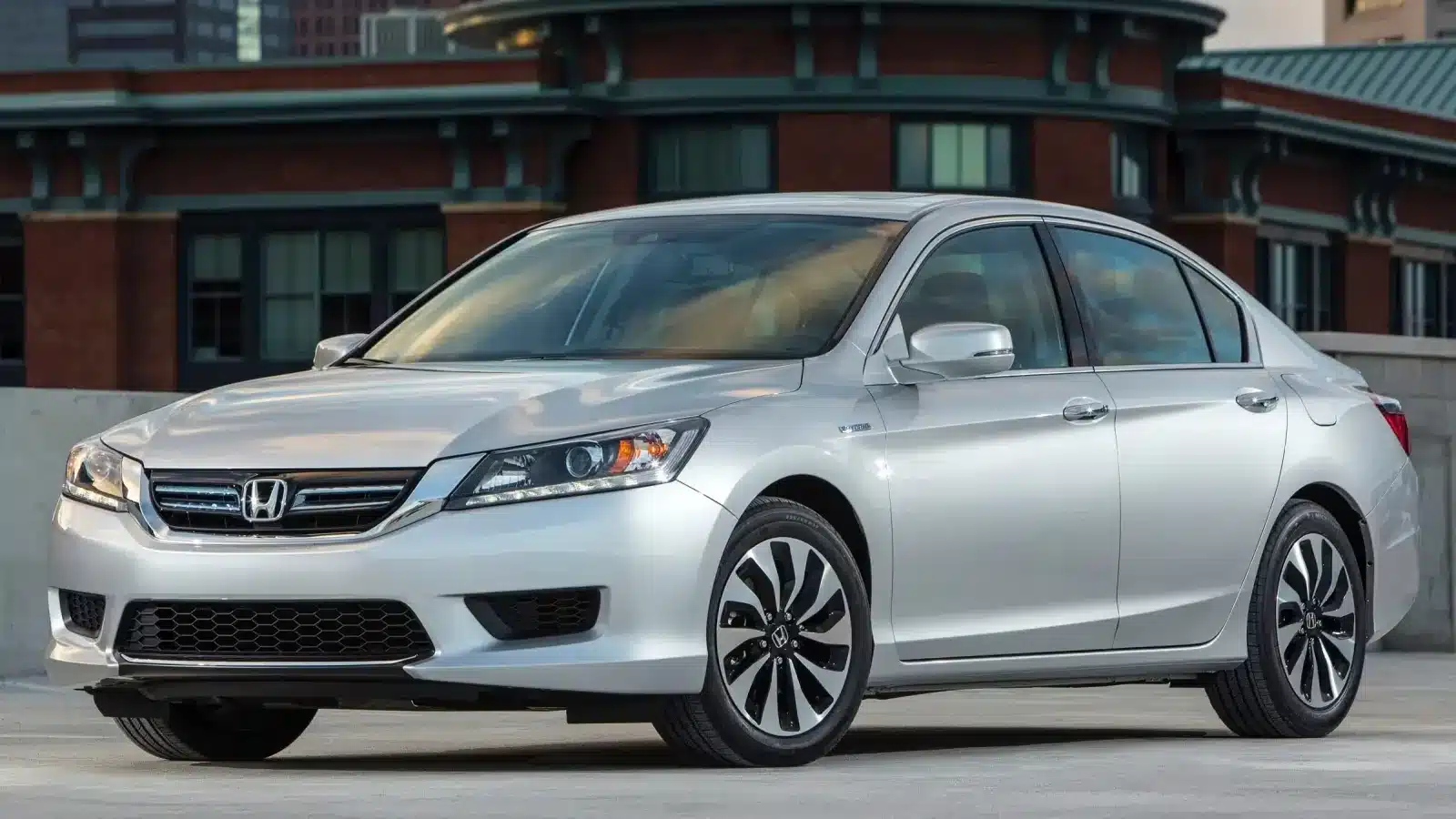 Silver Honda Accord parked in an urban environment, celebrated for its long-lasting reliability and value as a used car.