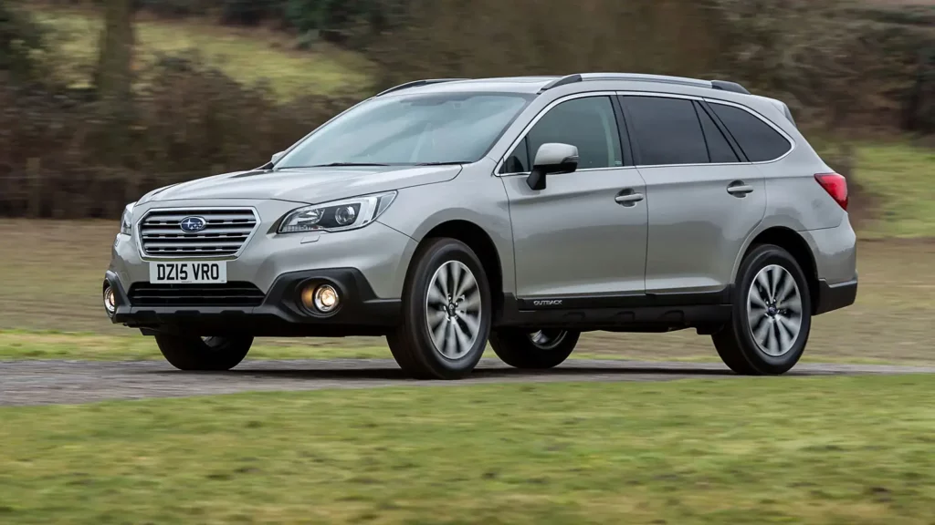 Silver Subaru Outback driving on a rural road, known for its durability, off-road capabilities, and dependability.