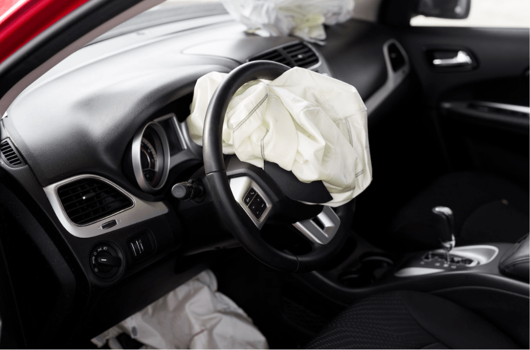Deployed airbags in car interior after crash – Diminished Value of Georgia, Car Appraisals for Insurance Claims Driver-side airbag has deployed in the car, with the steering wheel wrapped in the white bag and interior dashboard visible during a crash scenario | Diminished Value of Georgia, Car Appraisals for Insurance Claims