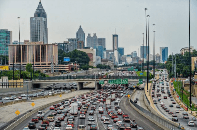 Atlanta Highway Traffic and Georgia Auto Insurance Rate Reductions – Diminished Value of Georgia, Car Appraisals for Insurance Claims Heavy traffic on an Atlanta interstate with the downtown skyline behind it, illustrating Georgia auto insurance rate reductions in 2026 | Diminished Value of Georgia, Car Appraisals for Insurance Claims
