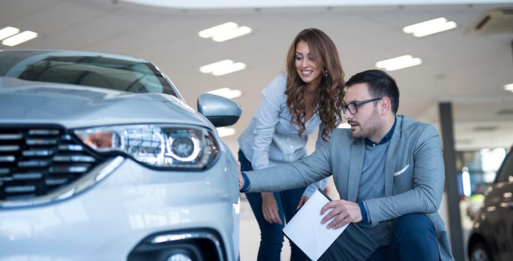 people-car-dealership-showroom-discussing-about-new-EV-vehicle