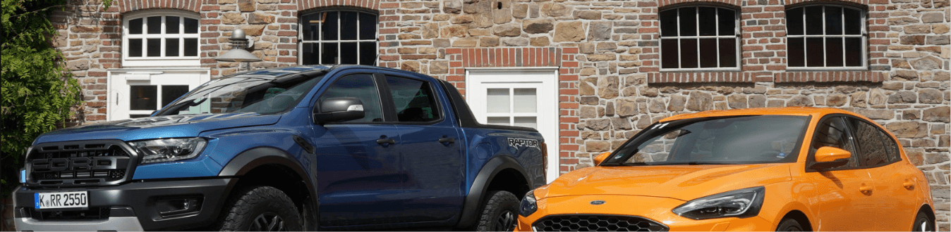 Pickup Truck and Sedan Parked Side by Side Outside a Stone Building – Diminished Value of Georgia, Car Appraisals for Insurance Claims A pickup truck and a sedan parked side by side, representing the 2026 used car market split between truck and SUV segments and softer sedan demand | Diminished Value of Georgia, Car Appraisals for Insurance Claims