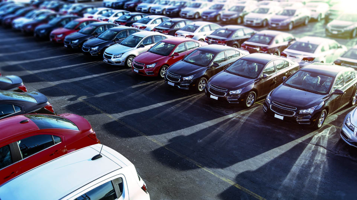 Aerial view of a large used car dealership lot with rows of vehicles, illustrating rising car values in Georgia amid auto tariffs. | Diminished Value of Georgia, Car Appraisals for Insurance Claims